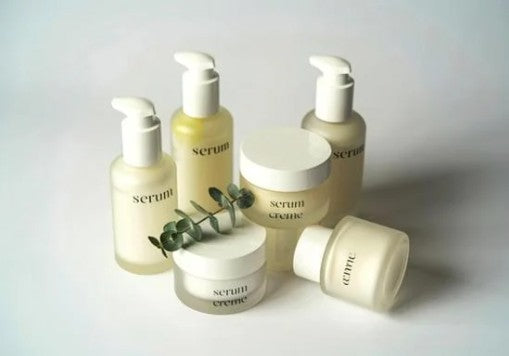Collection of skincare products labeled 'serum' and 'creme' on a light background